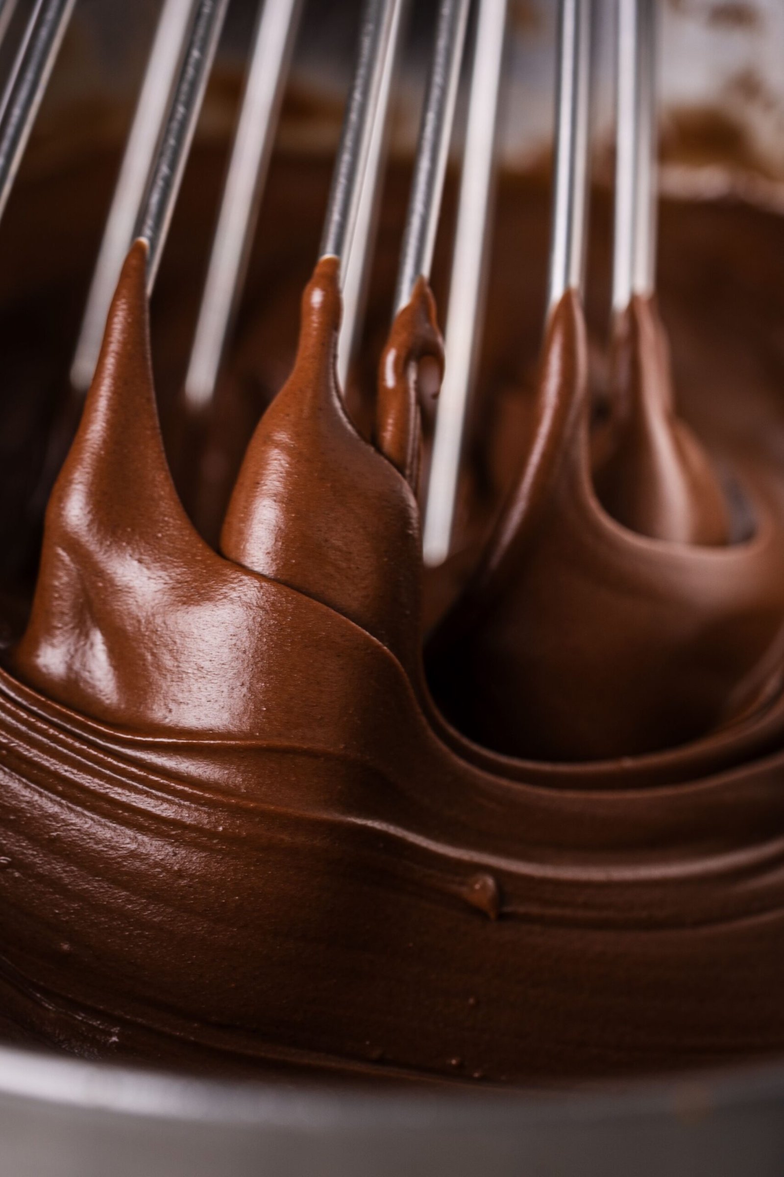 Rich chocolate batter being smoothly whisked for baking. Perfect for dessert inspiration.
